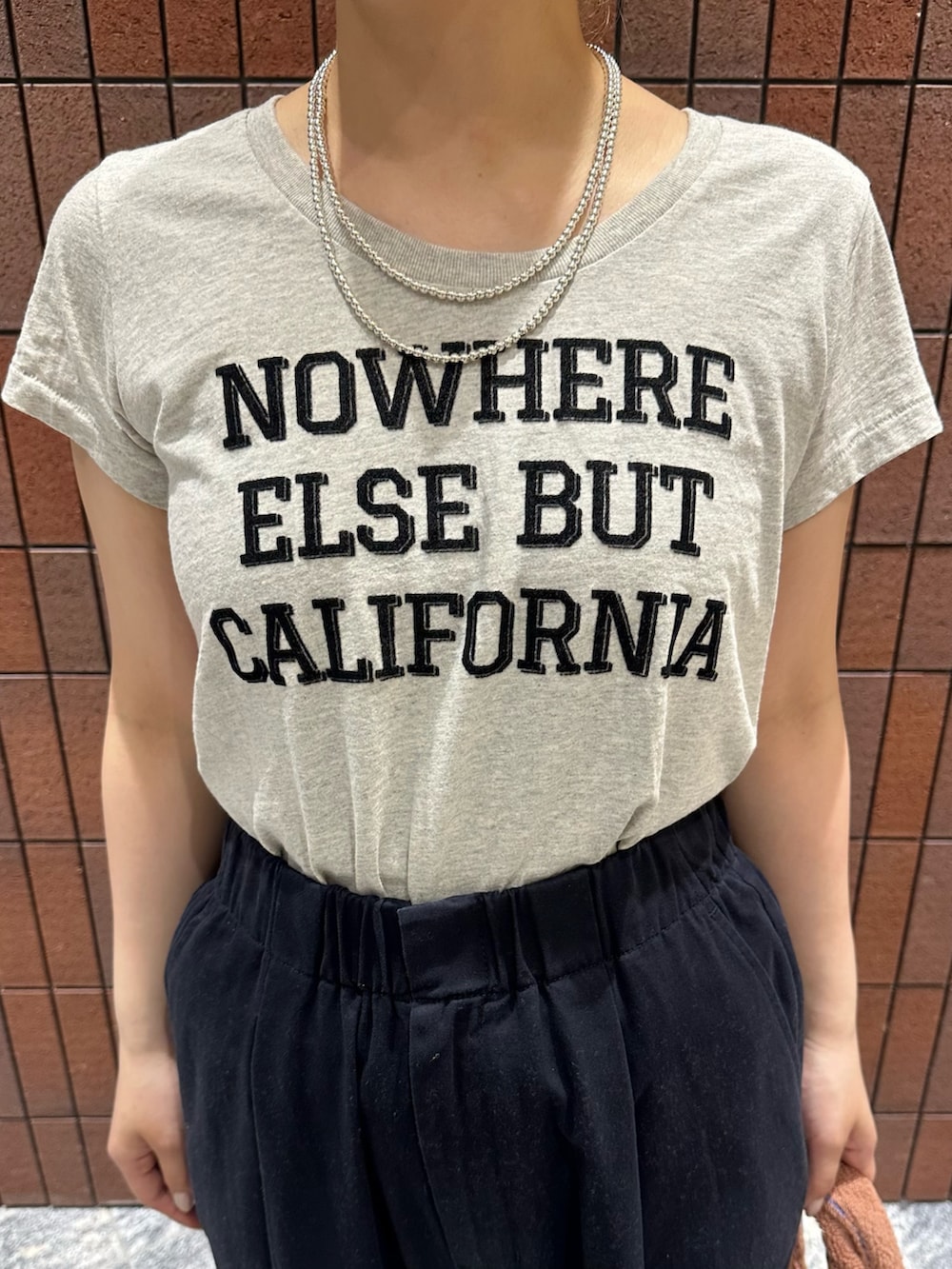 ブルー系のその他パンツ、イエロー系のハンドバッグ、グレー系のTシャツ/カットソーを着用したレディースの春コーディネートの4枚目の写真