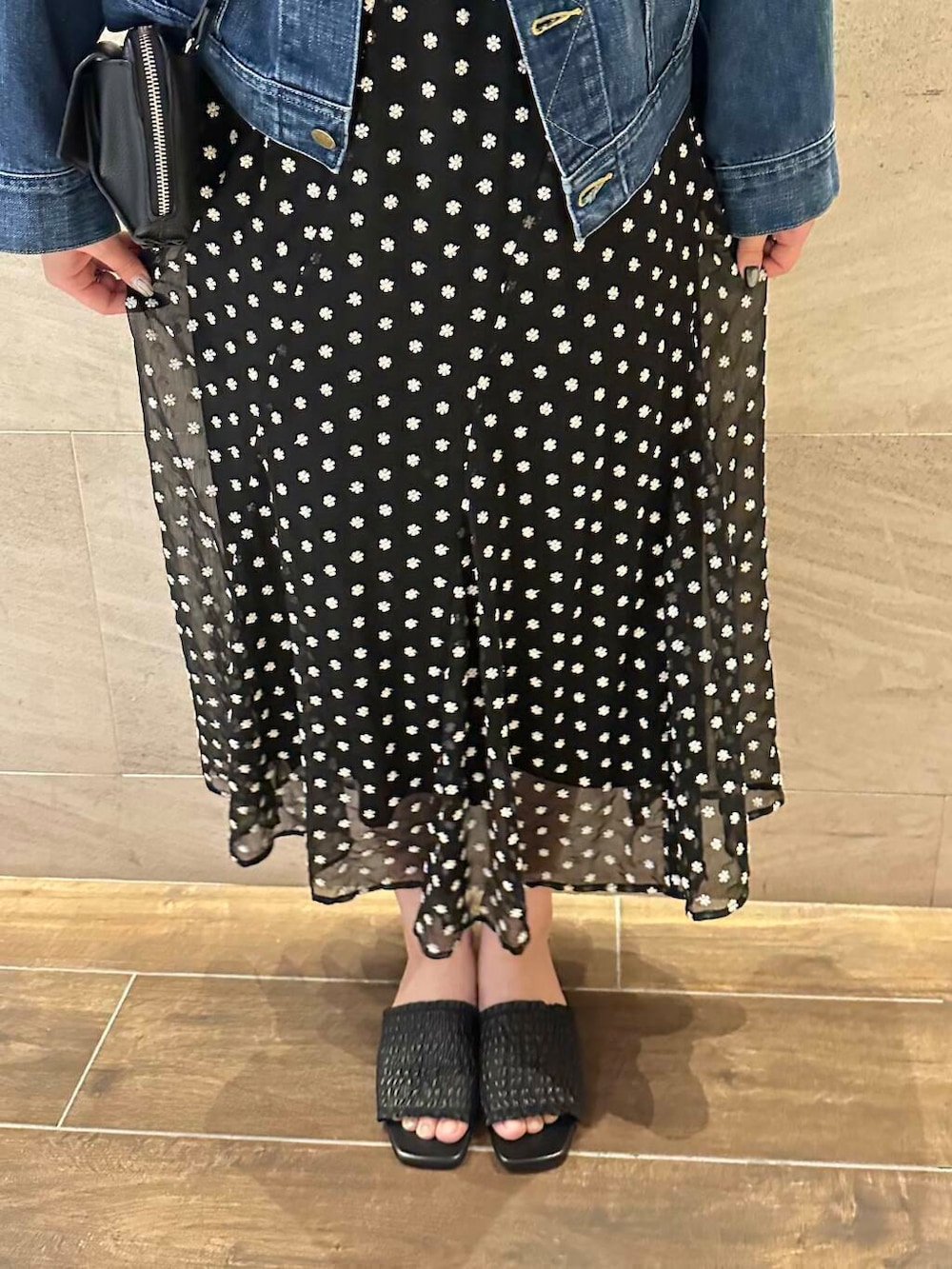 ブルー系のデニムジャケット、ブラック系のショルダーバッグ、ブラック系のスカートを着用したレディースの春コーディネートの2枚目の写真