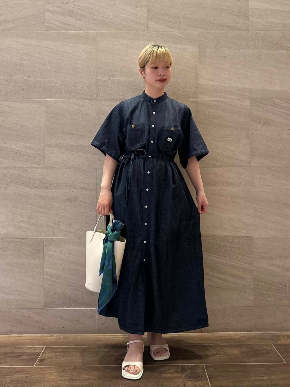 ホワイト系のサンダル、ホワイト系のハンドバッグ、ブルー系のワンピースを着用したレディースの夏コーディネートの3枚目の写真