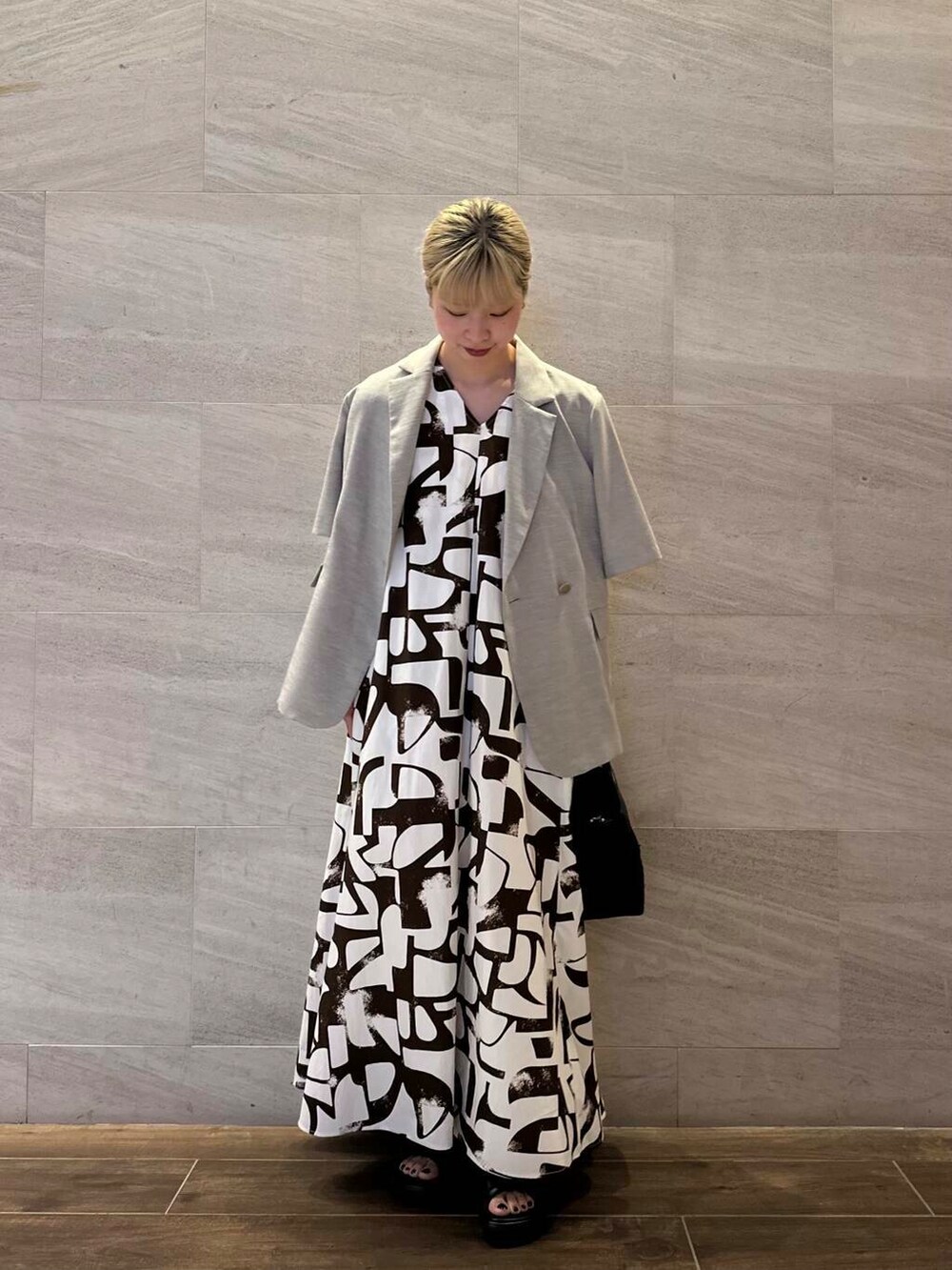 ブラック系のショルダーバッグ、ベージュ系のその他アウター、ブラウン系のワンピースを着用したレディースの夏コーディネートの3枚目の写真