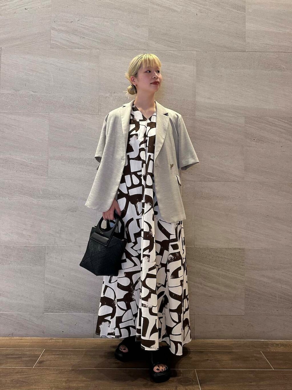 ブラック系のショルダーバッグ、ベージュ系のその他アウター、ブラウン系のワンピースを着用したレディースの夏コーディネートの2枚目の写真