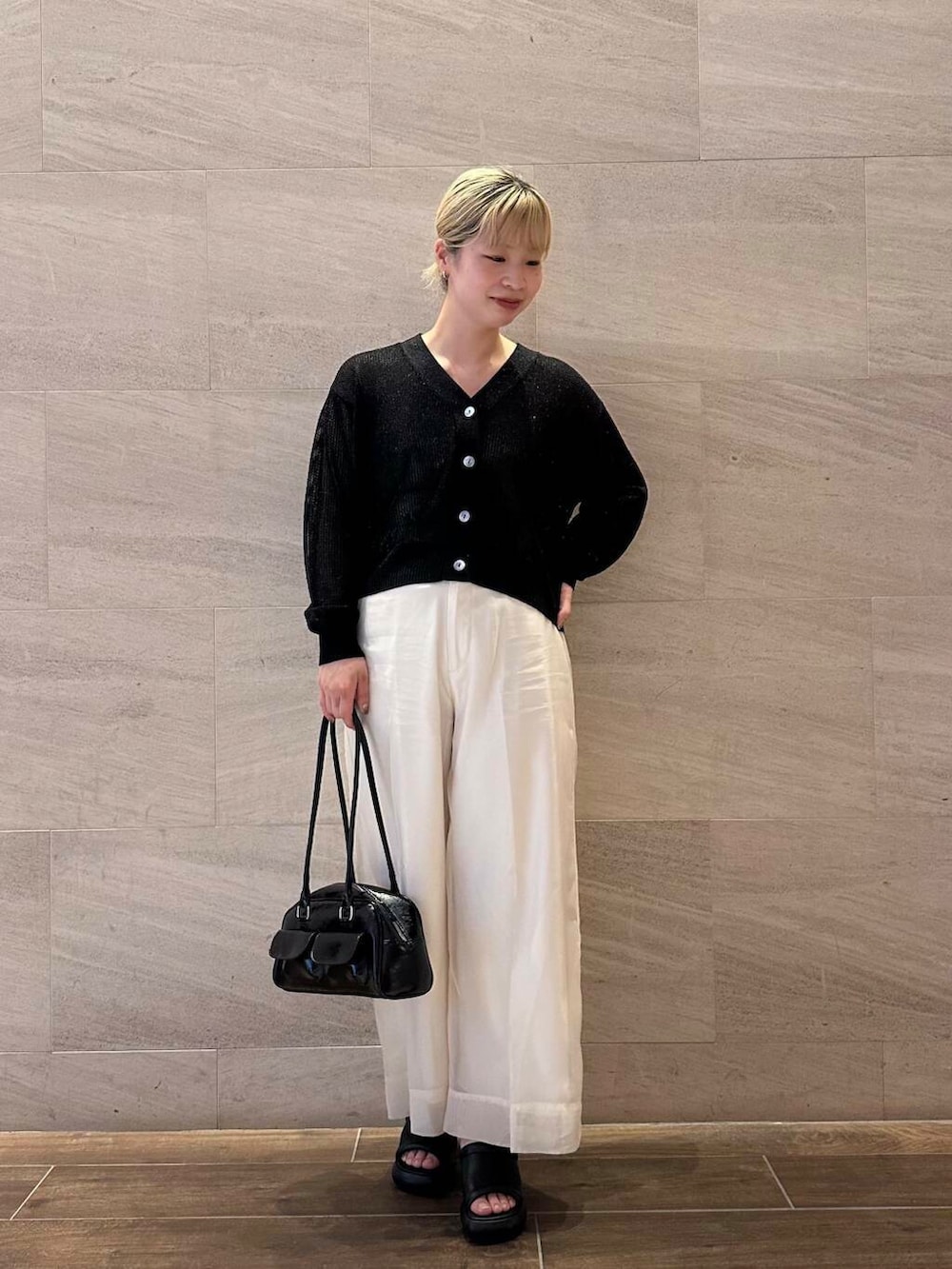 ホワイト系のその他パンツ、ベージュ系のタンクトップ、ブラック系のカーディガン/ボレロを着用したレディースの春コーディネートの3枚目の写真