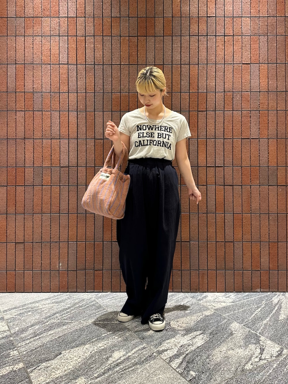 ブルー系のその他パンツ、イエロー系のハンドバッグ、グレー系のTシャツ/カットソーを着用したレディースの春コーディネートの5枚目の写真