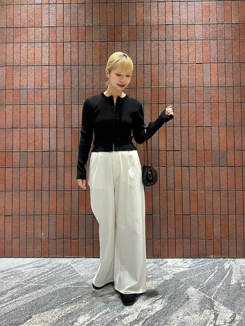 ブラック系のカーディガン/ボレロ、ホワイト系のデニムパンツ、ブラック系のショルダーバッグを着用したレディースの春コーディネートの5枚目の写真