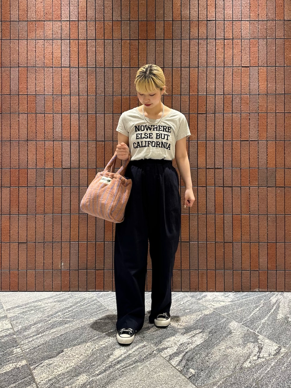 ブルー系のその他パンツ、イエロー系のハンドバッグ、グレー系のTシャツ/カットソーを着用したレディースの春コーディネートの2枚目の写真