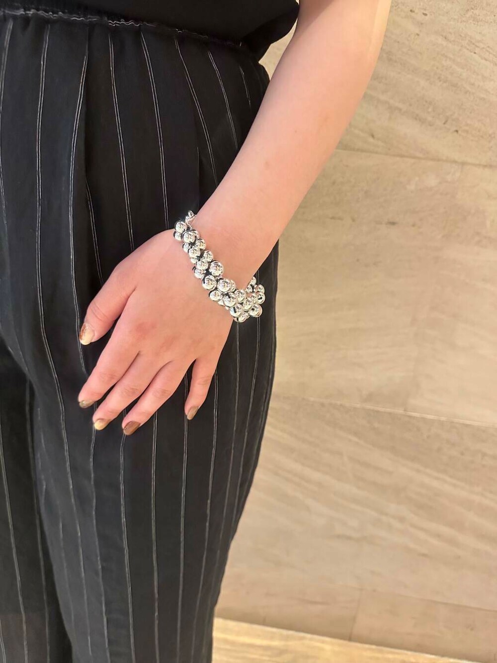 ベージュ系のかごバッグ、ブラック系のTシャツ/カットソー、ブラック系のその他パンツを着用したレディースの春コーディネートの4枚目の写真