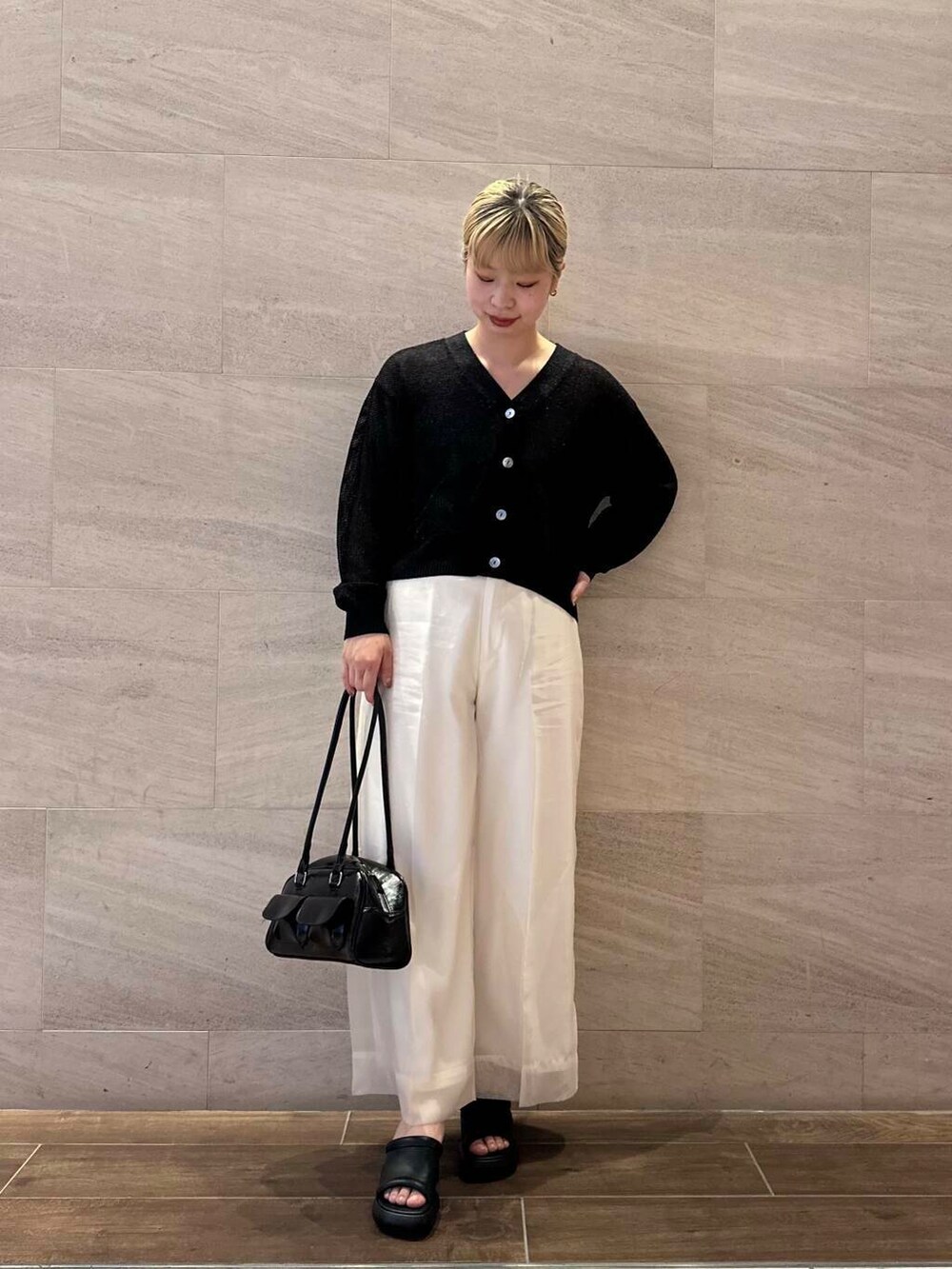 ホワイト系のその他パンツ、ベージュ系のタンクトップ、ブラック系のカーディガン/ボレロを着用したレディースの春コーディネートの2枚目の写真