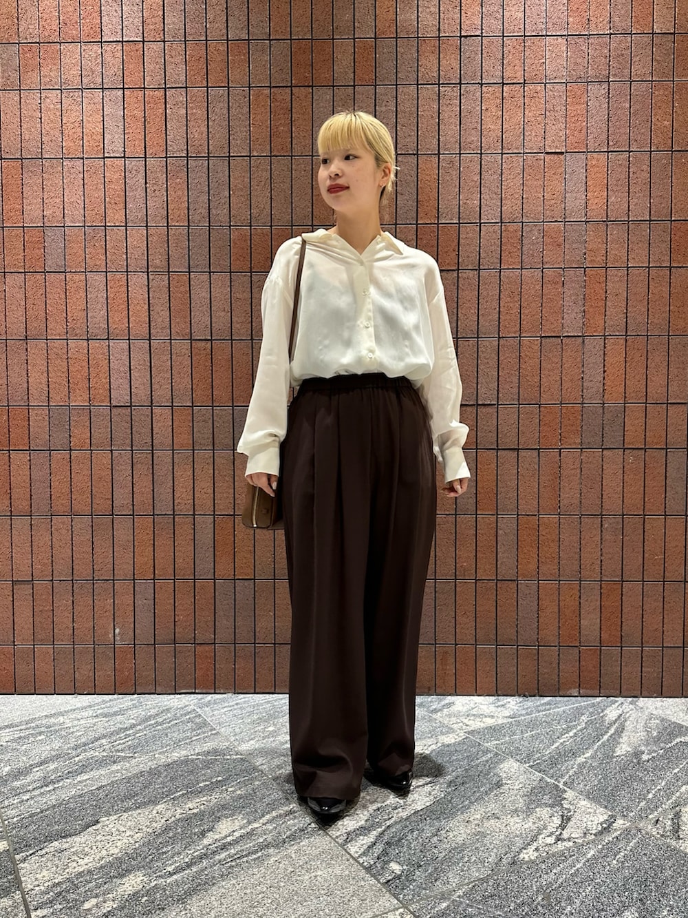 ホワイト系のシャツ/ブラウス、ブラック系のパンプス、ブラウン系のボストンバッグを着用したレディースの春コーディネートの4枚目の写真