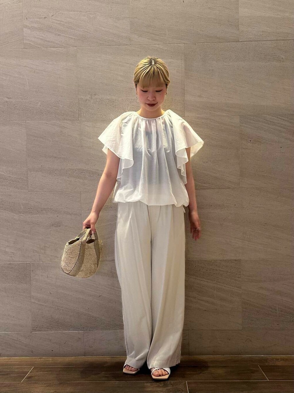 ベージュ系のかごバッグ、ベージュ系のその他パンツ、ホワイト系のシャツ/ブラウスを着用したレディースの春コーディネートの3枚目の写真