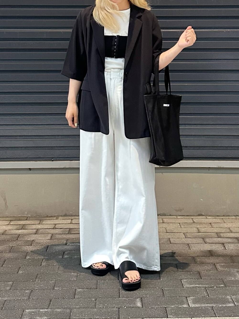 ホワイト系のデニムパンツ、ホワイト系のTシャツ/カットソー、ブラック系のその他アウターを着用したレディースの春コーディネートの5枚目の写真