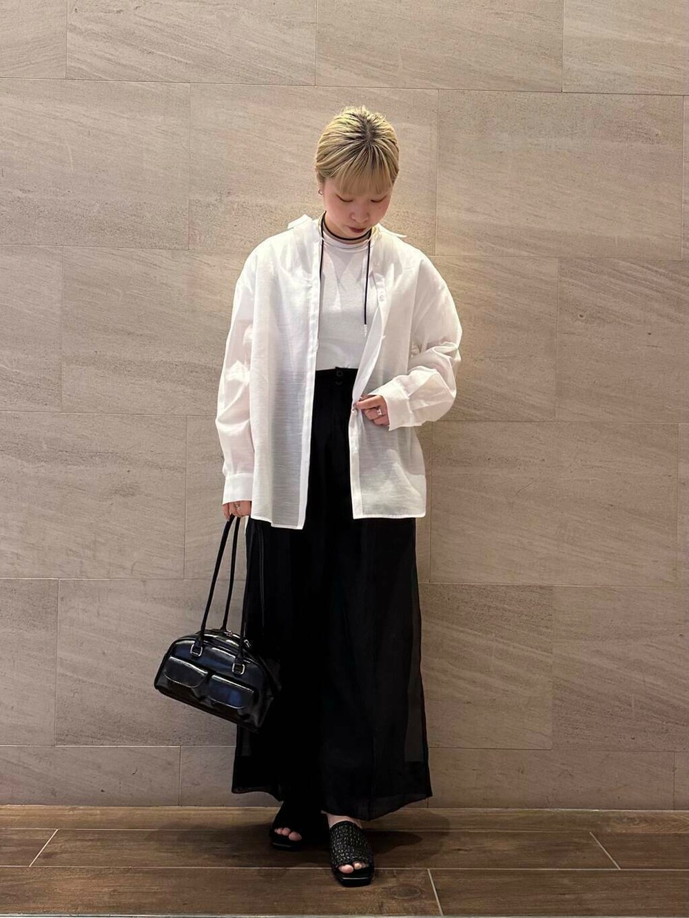 ブラック系のその他パンツ、ホワイト系のシャツ/ブラウス、ブラック系のボストンバッグを着用したレディースの春コーディネートの2枚目の写真