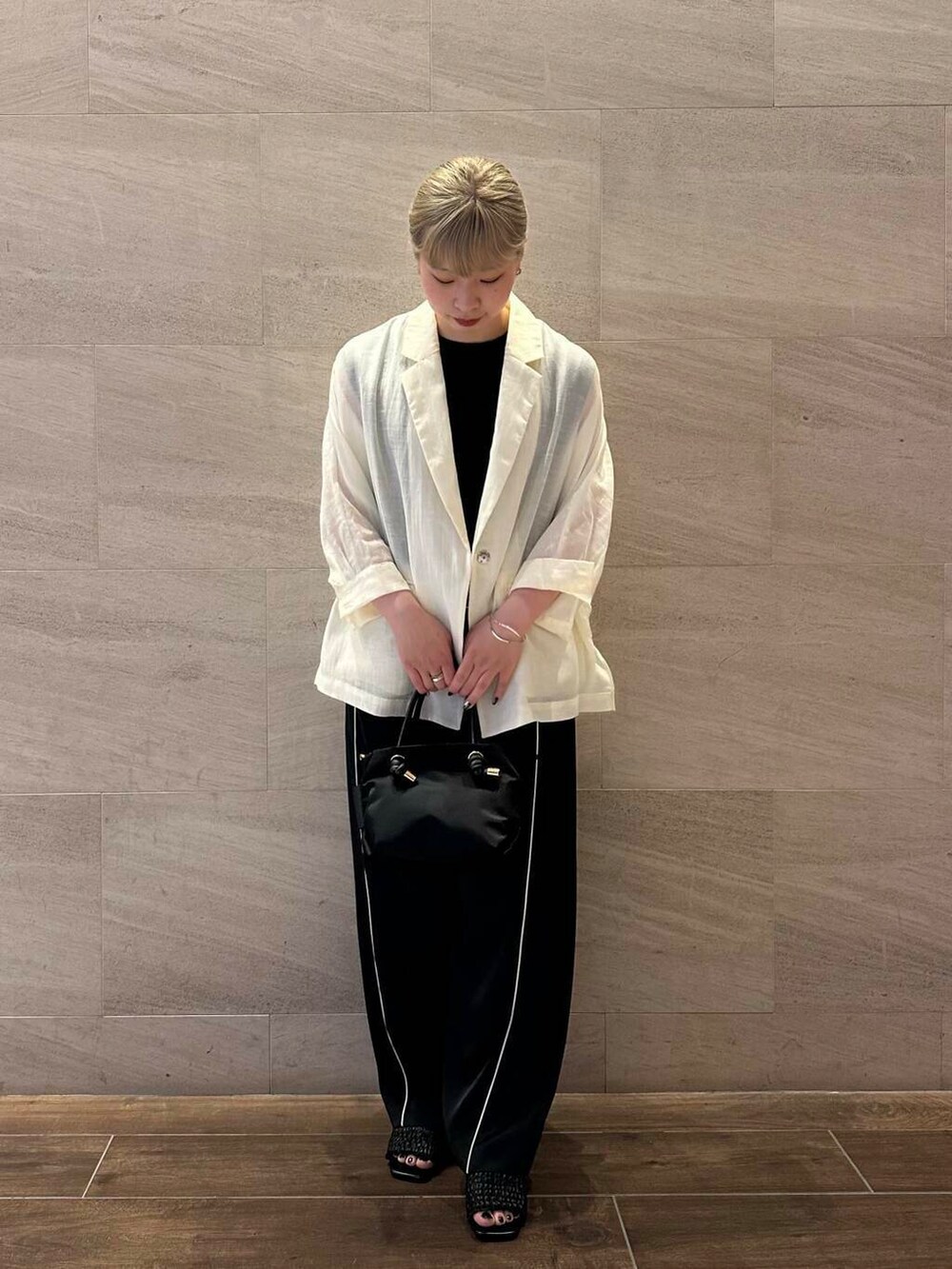 ブラック系のトートバッグ、ブラック系のニット/セーター、ホワイト系のその他アウターを着用したレディースの夏コーディネートの4枚目の写真