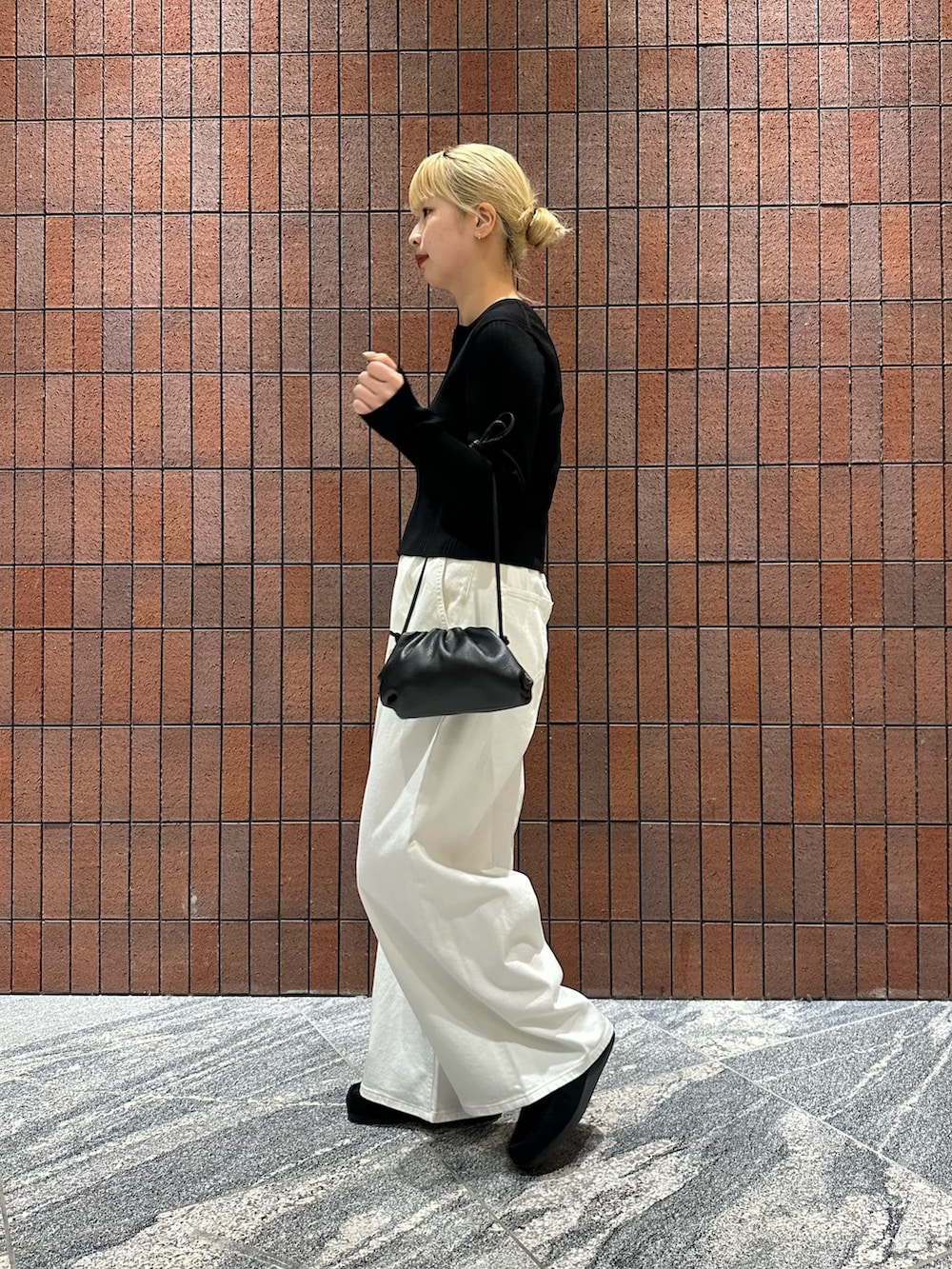 ブラック系のカーディガン/ボレロ、ホワイト系のデニムパンツ、ブラック系のショルダーバッグを着用したレディースの春コーディネートの3枚目の写真