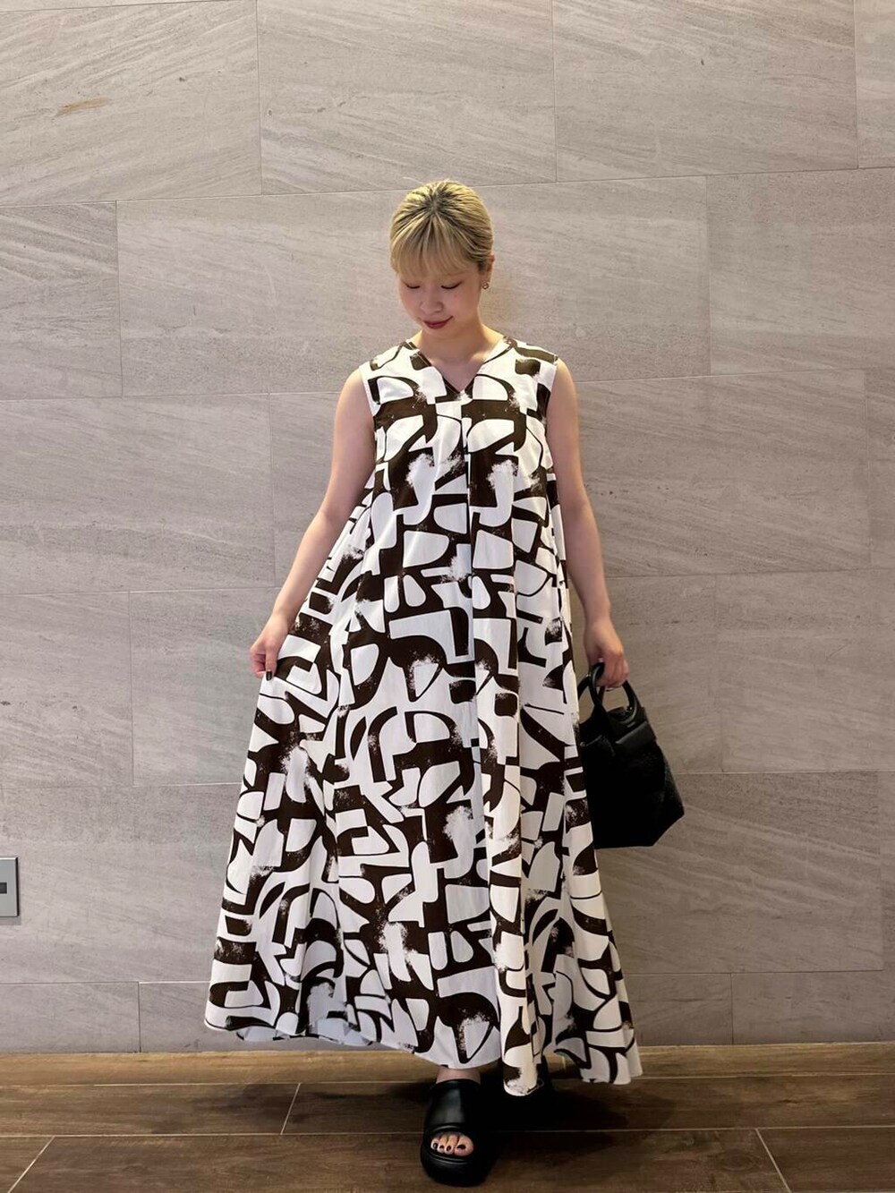 ブラック系のショルダーバッグ、ベージュ系のその他アウター、ブラウン系のワンピースを着用したレディースの夏コーディネートの4枚目の写真