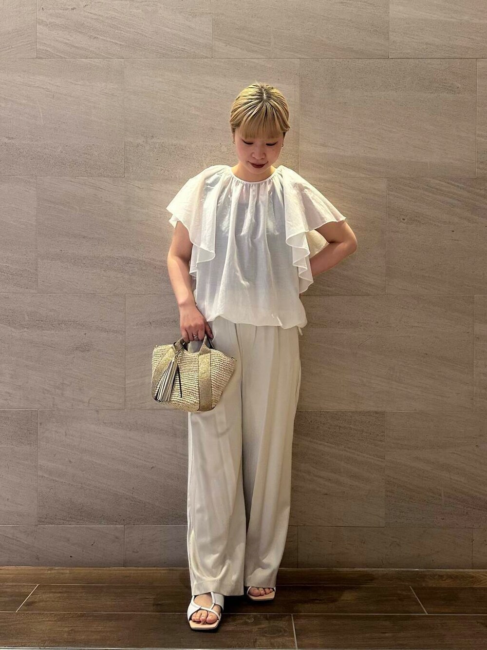 ベージュ系のかごバッグ、ベージュ系のその他パンツ、ホワイト系のシャツ/ブラウスを着用したレディースの春コーディネートの2枚目の写真