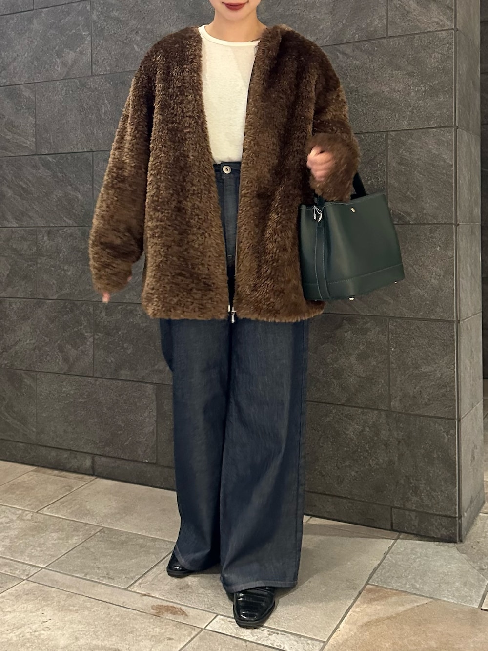 ブラウン系のノーカラージャケット、ホワイト系のTシャツ/カットソー、ブルー系のデニムパンツを着用したレディースの秋コーディネートの2枚目の写真