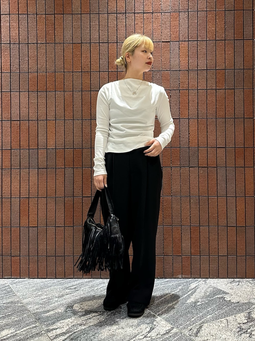 ホワイト系のTシャツ/カットソー、ブラック系のその他パンツ、ブラック系のハンドバッグを着用したレディースの春コーディネートの4枚目の写真
