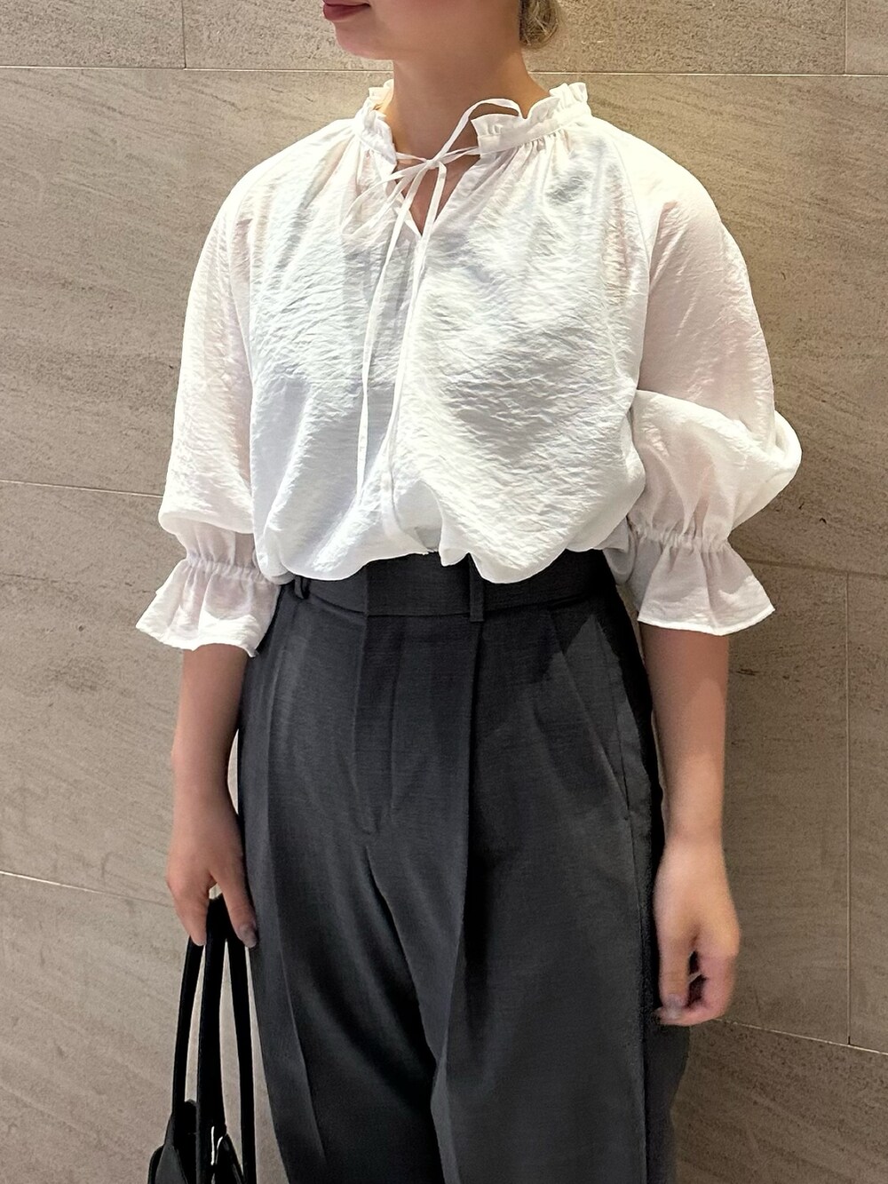 グレー系のその他パンツ、ホワイト系のシャツ/ブラウス、ブラック系のトートバッグを着用したレディースの秋コーディネートの3枚目の写真