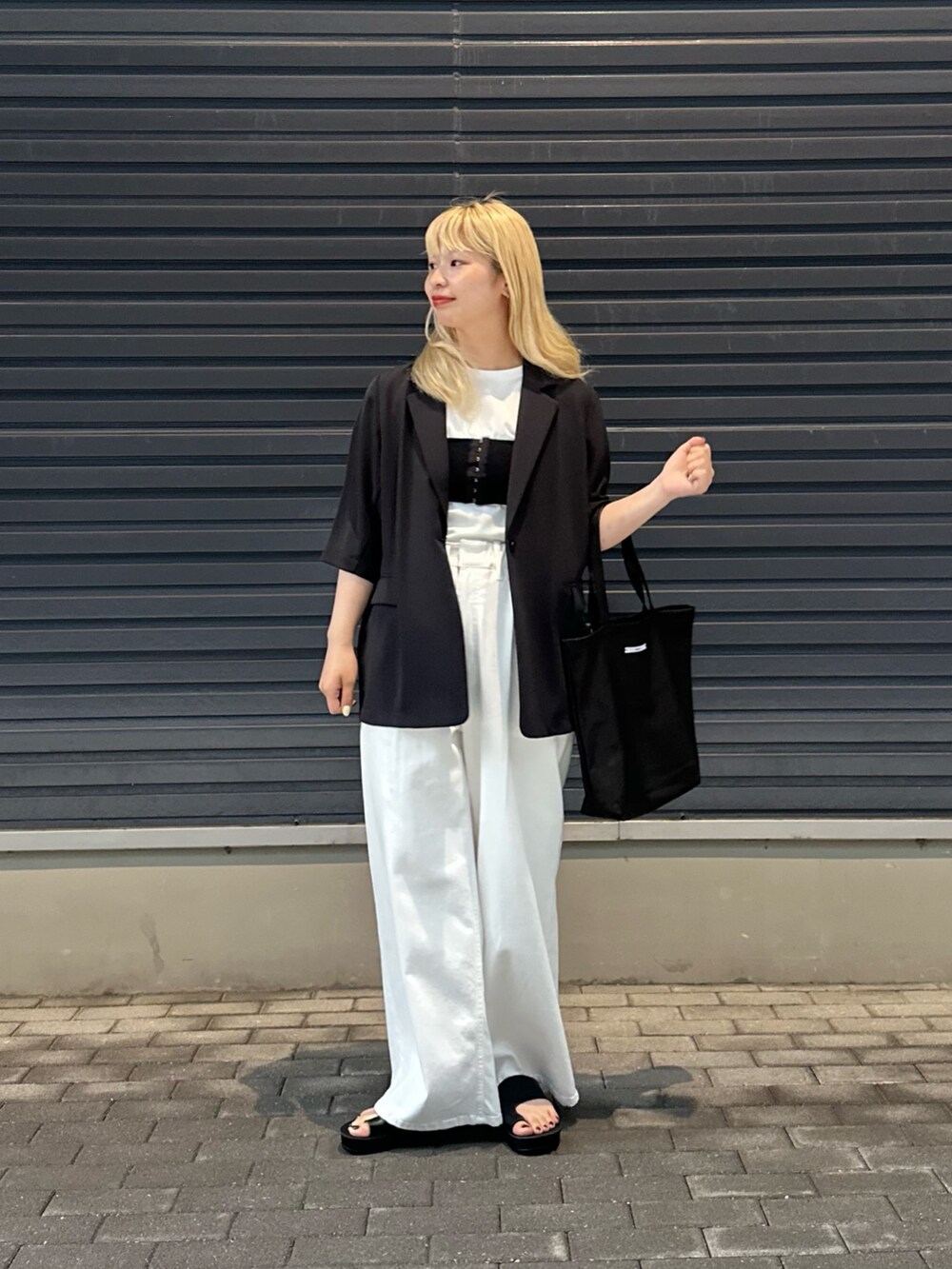 ホワイト系のデニムパンツ、ホワイト系のTシャツ/カットソー、ブラック系のその他アウターを着用したレディースの春コーディネートの4枚目の写真