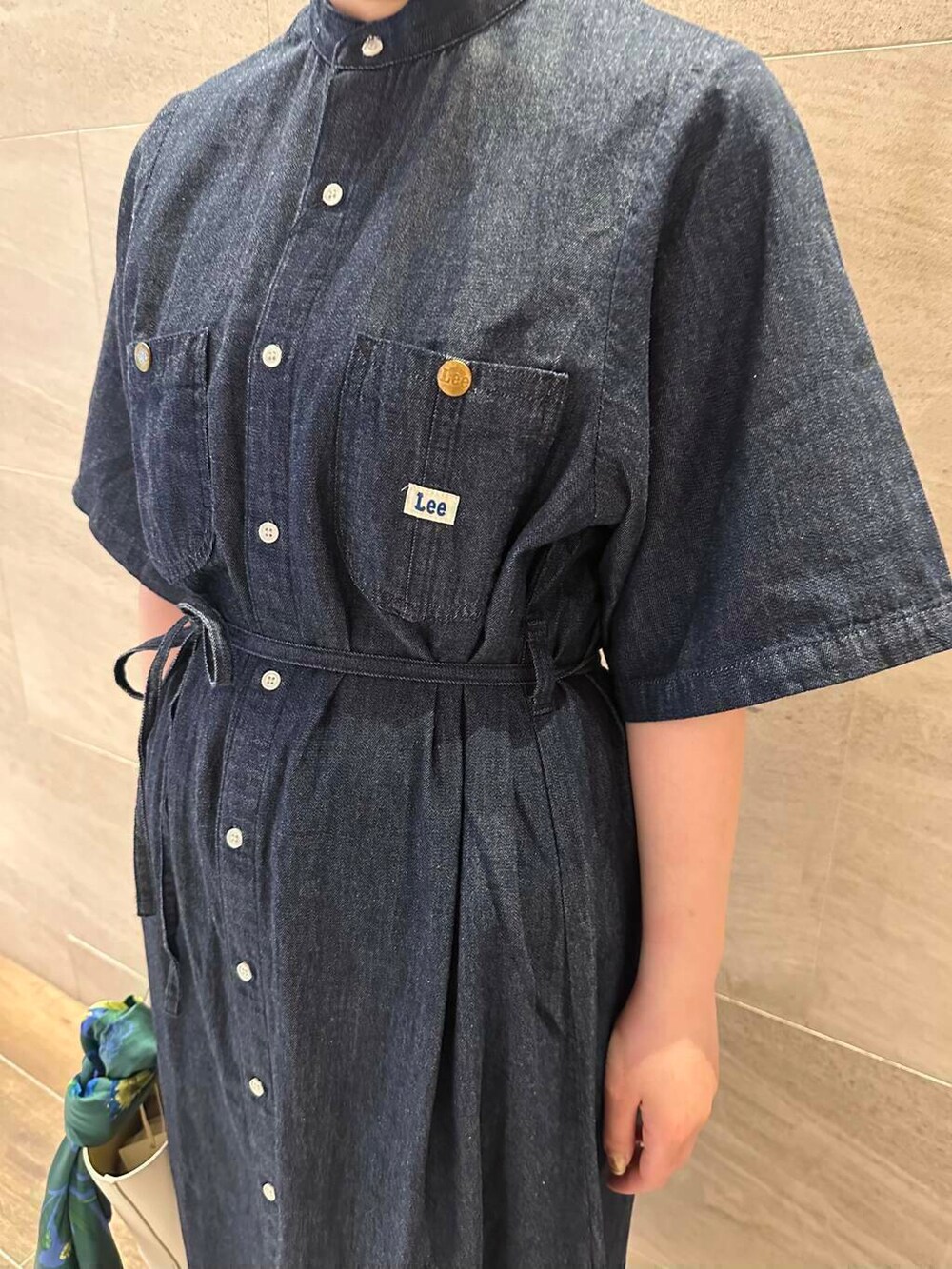 ホワイト系のサンダル、ホワイト系のハンドバッグ、ブルー系のワンピースを着用したレディースの夏コーディネートの6枚目の写真