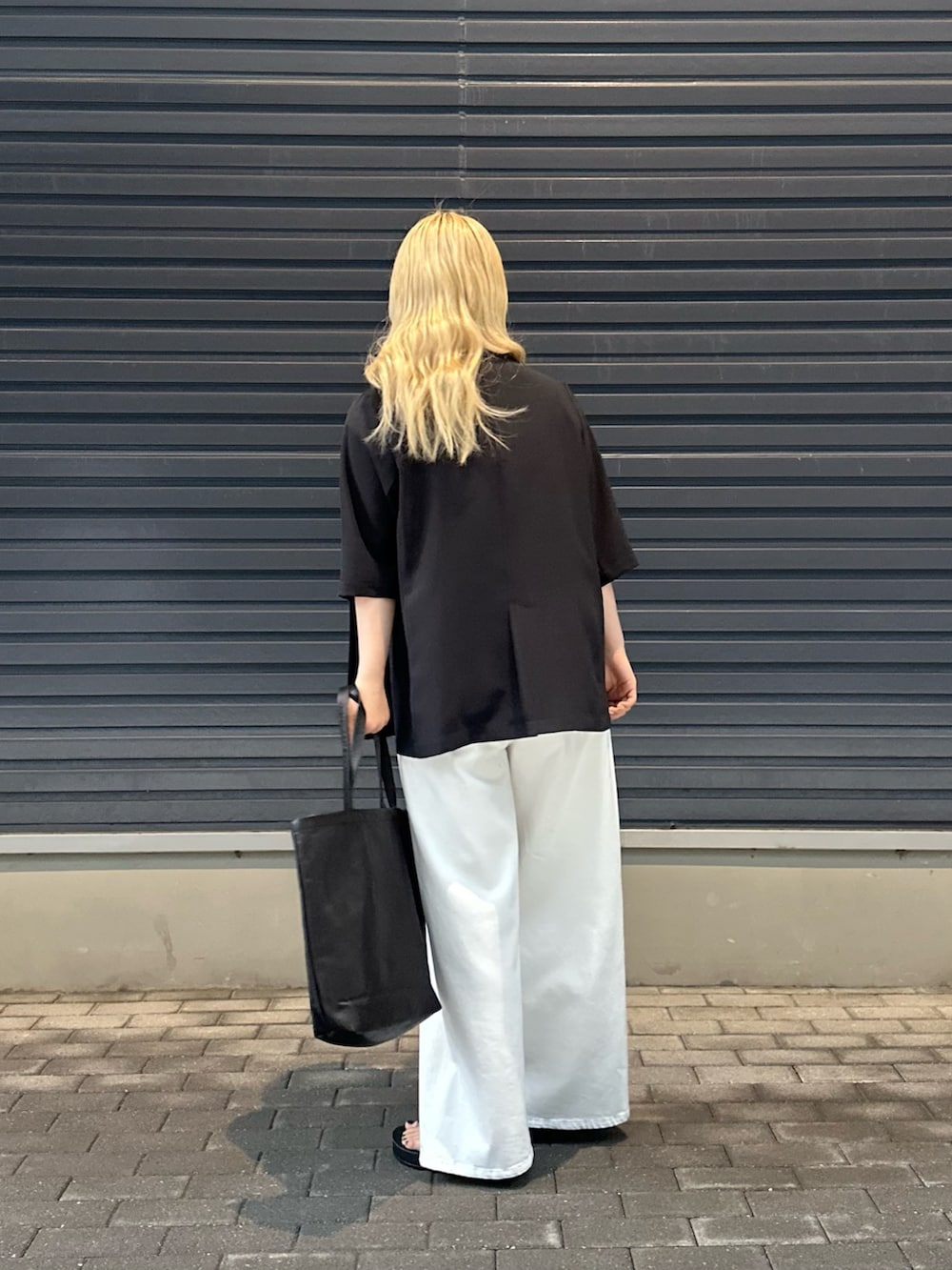 ホワイト系のデニムパンツ、ホワイト系のTシャツ/カットソー、ブラック系のその他アウターを着用したレディースの春コーディネートの3枚目の写真