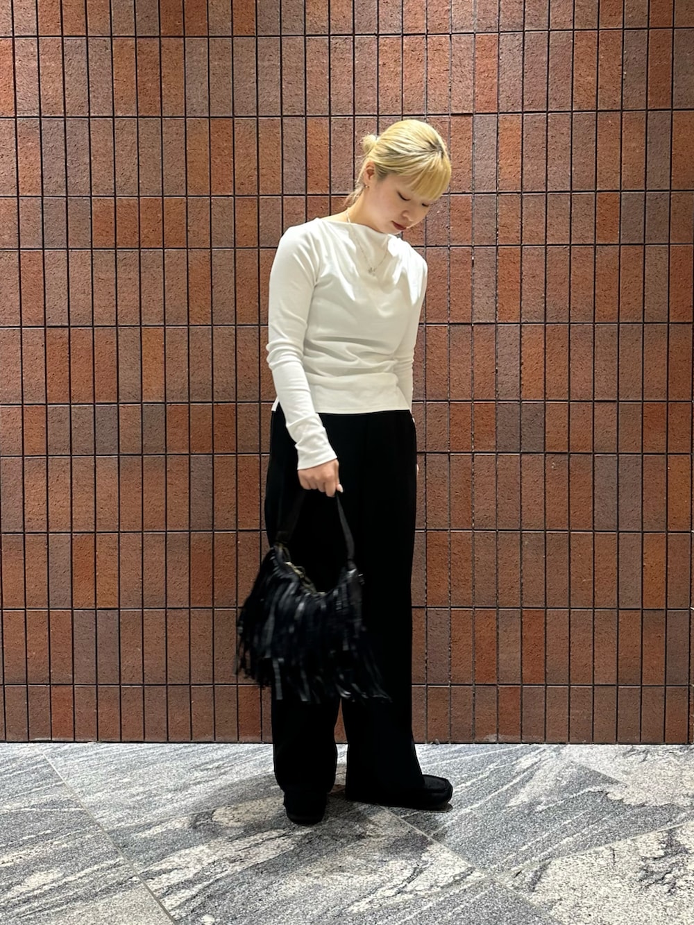 ホワイト系のTシャツ/カットソー、ブラック系のその他パンツ、ブラック系のハンドバッグを着用したレディースの春コーディネートの2枚目の写真