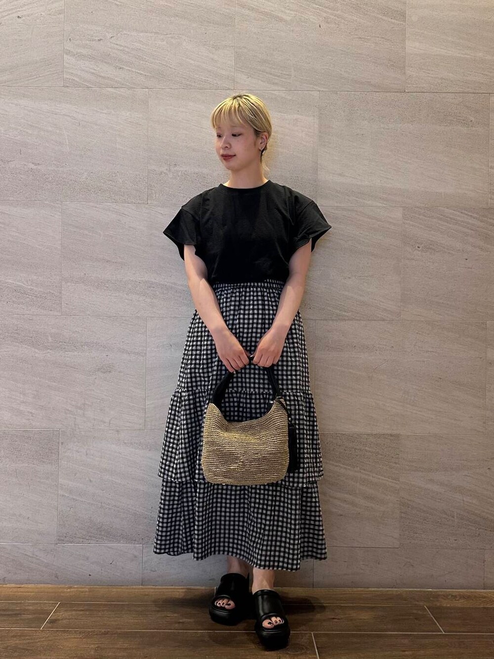 ブラウン系のかごバッグ、その他のスカート、ブラック系のTシャツ/カットソーを着用したレディースの夏コーディネートの3枚目の写真