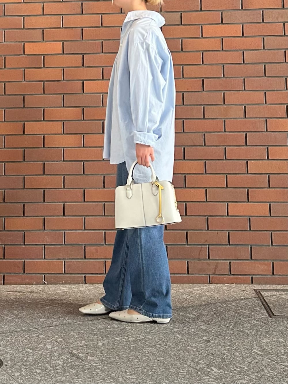 ブルー系のシャツ/ブラウス、ブルー系のデニムパンツ、ホワイト系のハンドバッグを着用したレディースの春コーディネートの3枚目の写真