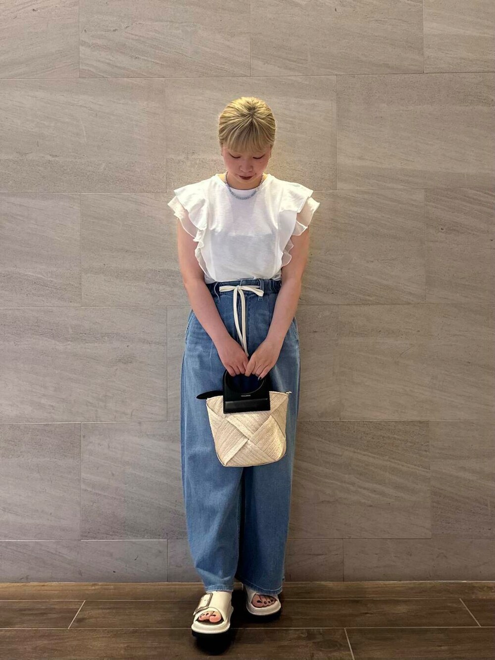 ベージュ系のショルダーバッグ、ブルー系のデニムパンツ、ホワイト系のTシャツ/カットソーを着用したレディースの夏コーディネートの3枚目の写真