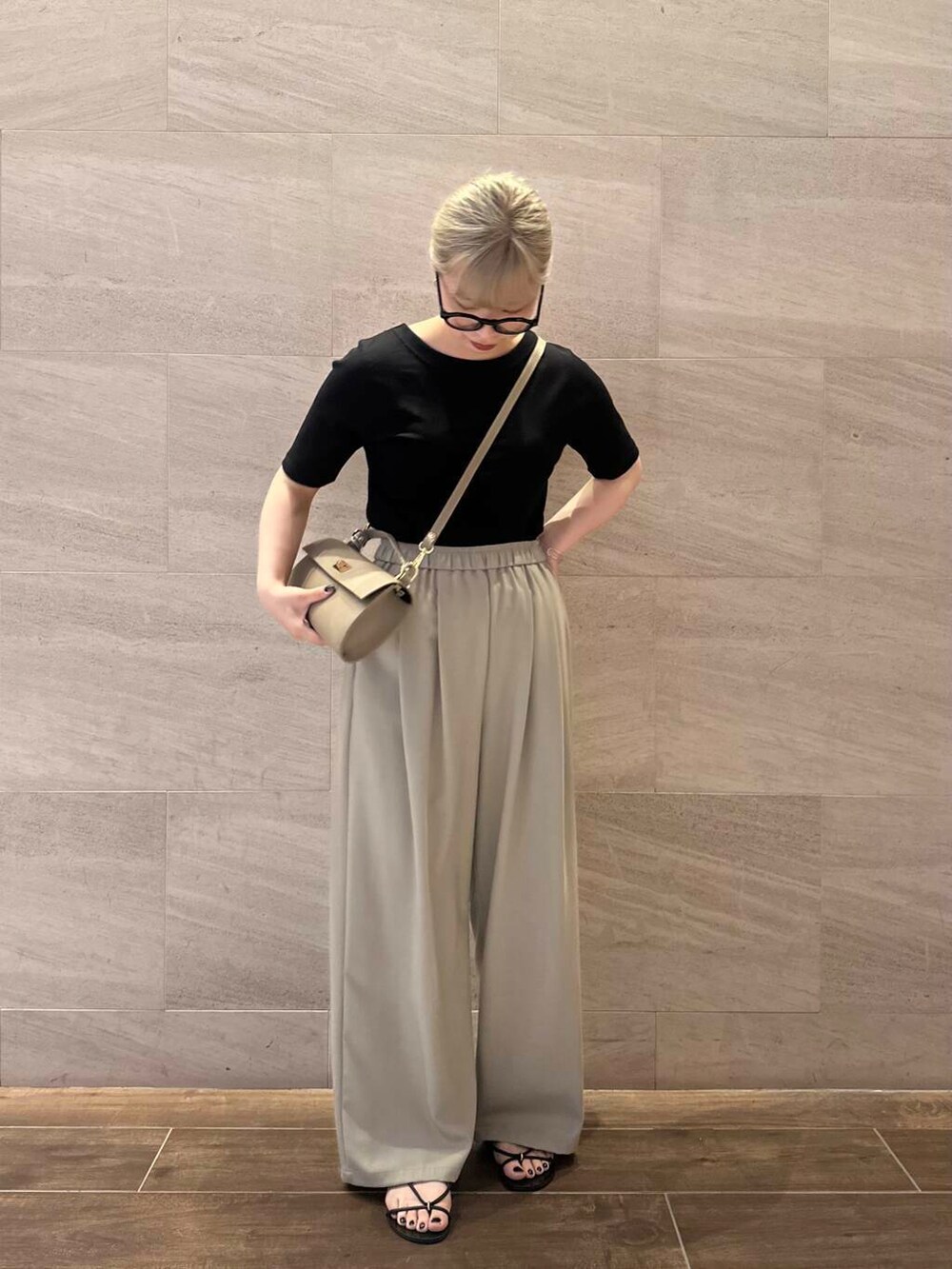 ベージュ系のその他パンツ、ベージュ系のショルダーバッグ、ブラック系のTシャツ/カットソーを着用したレディースの夏コーディネートの2枚目の写真