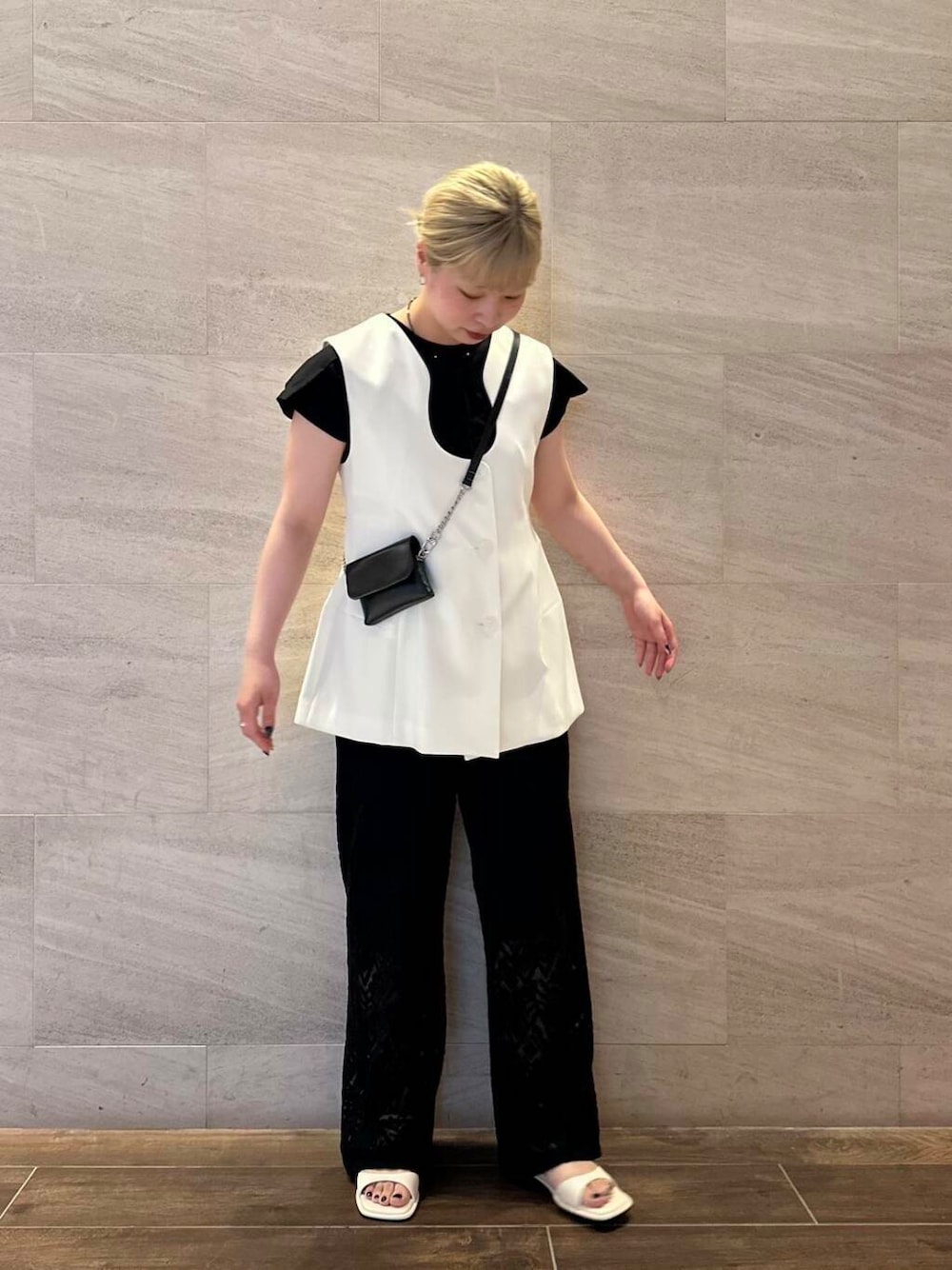 ホワイト系のサンダル、ブラック系のTシャツ/カットソー、ブラック系のその他パンツを着用したレディースの夏コーディネートの3枚目の写真