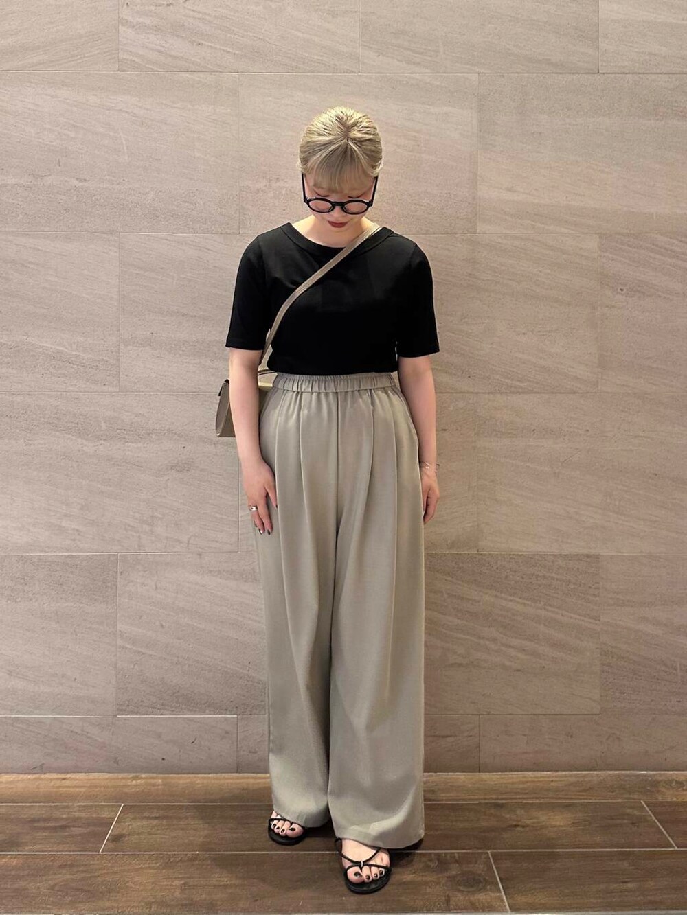 ベージュ系のその他パンツ、ベージュ系のショルダーバッグ、ブラック系のTシャツ/カットソーを着用したレディースの夏コーディネートの3枚目の写真