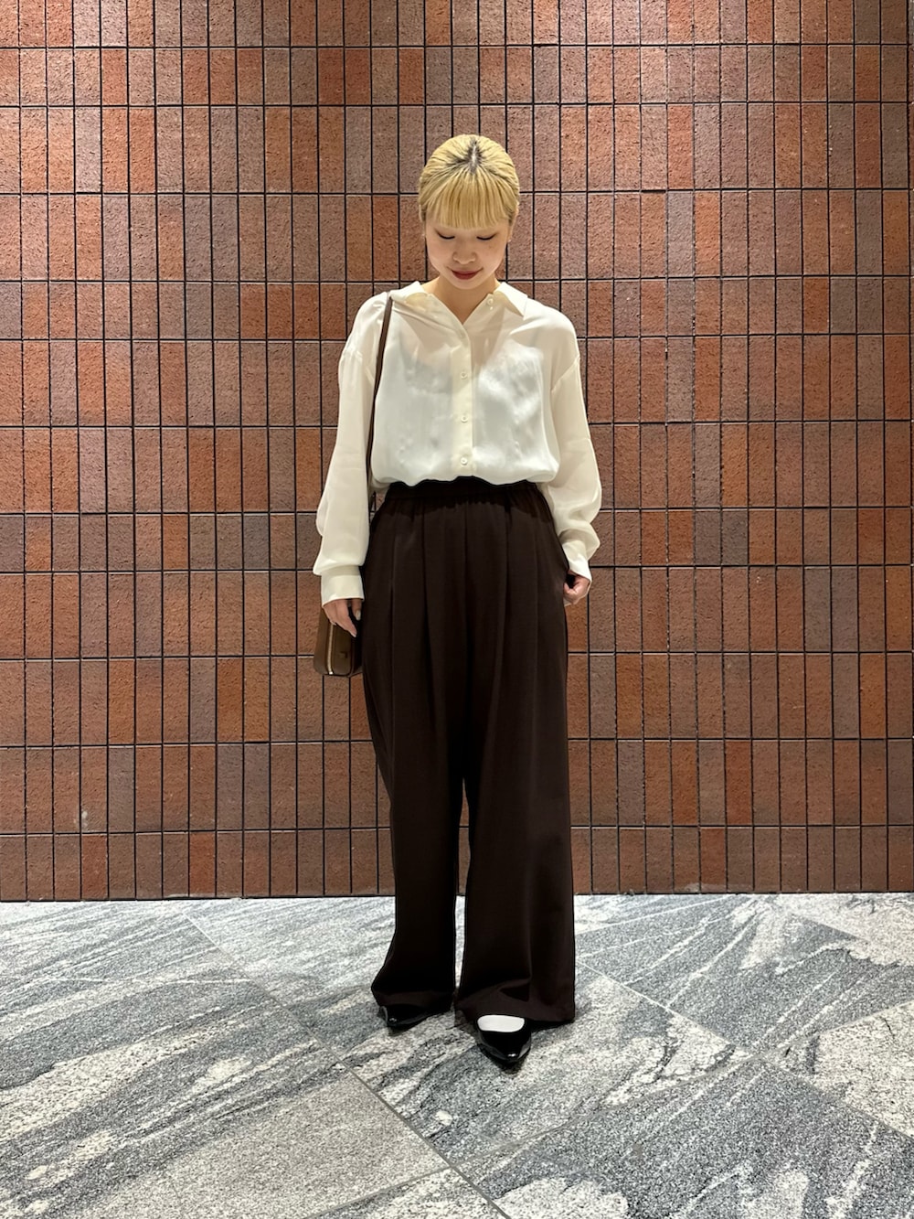 ホワイト系のシャツ/ブラウス、ブラック系のパンプス、ブラウン系のボストンバッグを着用したレディースの春コーディネートの3枚目の写真