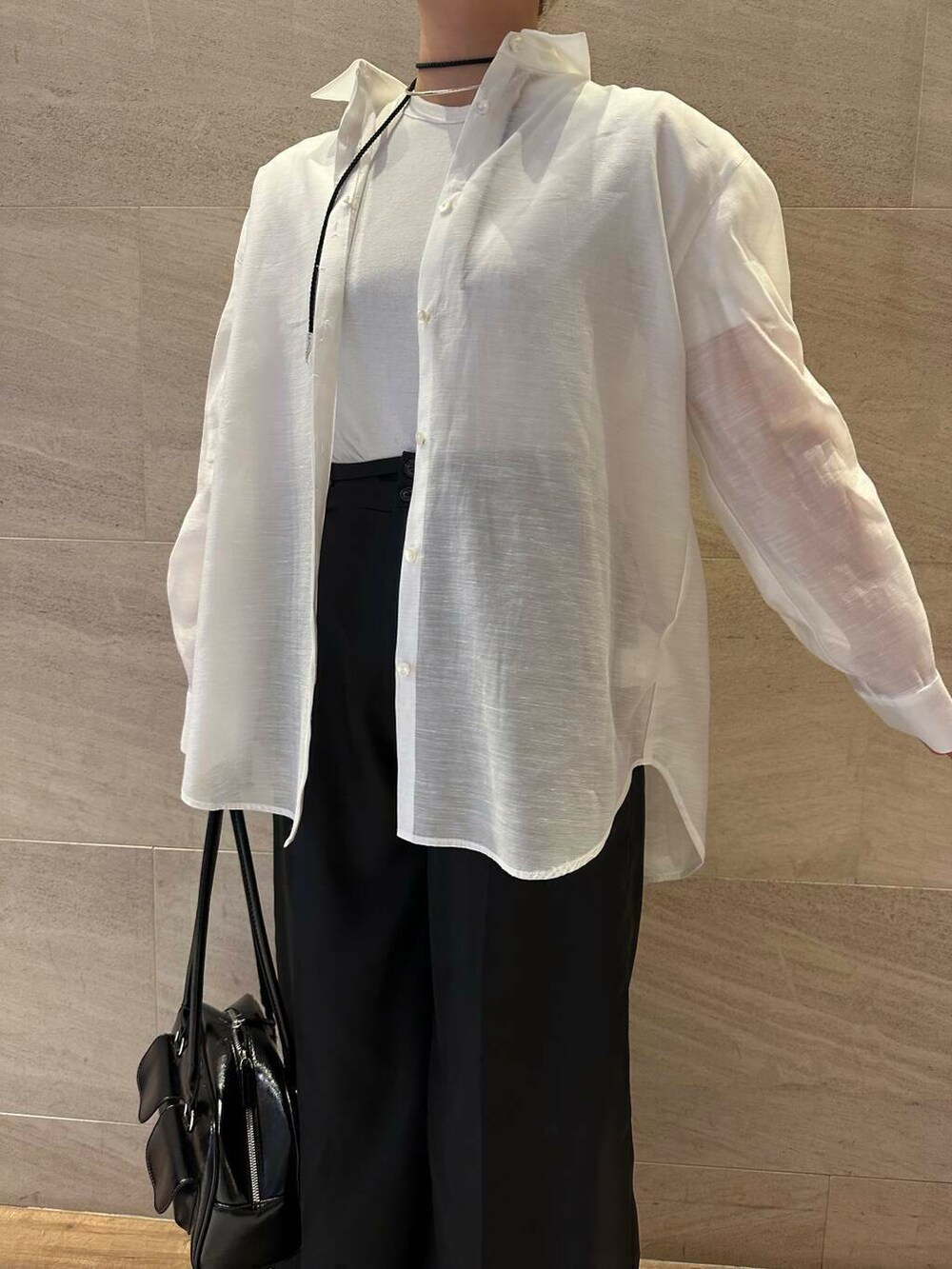 ブラック系のその他パンツ、ホワイト系のシャツ/ブラウス、ブラック系のボストンバッグを着用したレディースの春コーディネートの6枚目の写真