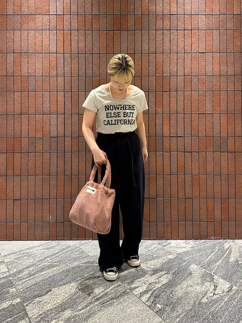 ブルー系のその他パンツ、イエロー系のハンドバッグ、グレー系のTシャツ/カットソーを着用したレディースの春コーディネートの3枚目の写真