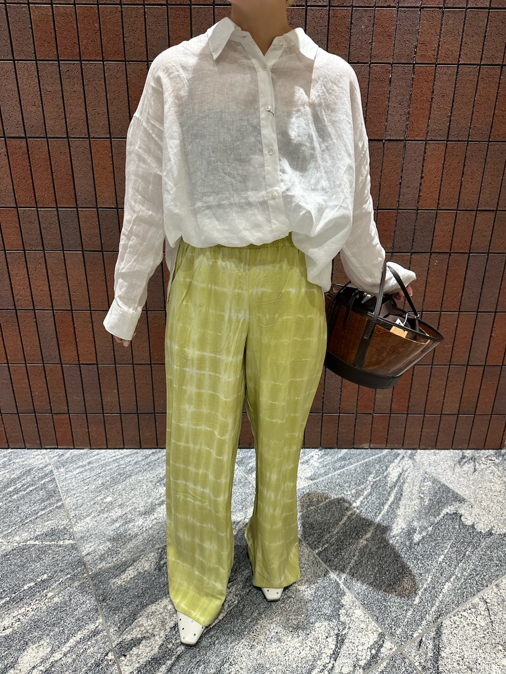 ホワイト系のシャツ/ブラウス、グリーン系のその他パンツ、ブラウン系のかごバッグを着用したレディースの春コーディネートの4枚目の写真
