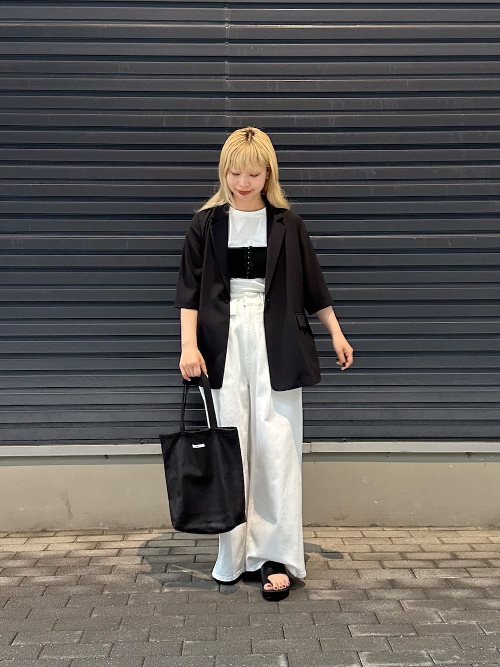 ホワイト系のデニムパンツ、ホワイト系のTシャツ/カットソー、ブラック系のその他アウターを着用したレディースの春コーディネートの2枚目の写真
