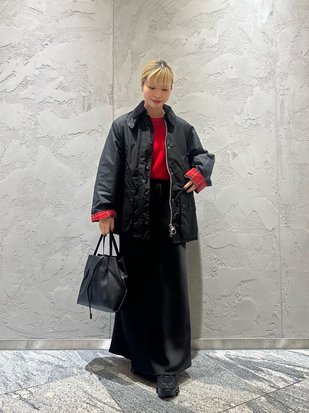 ブラック系のスカート、ブラック系のショルダーバッグ、ブラック系のテーラードジャケットを着用したレディースの冬コーディネートの3枚目の写真