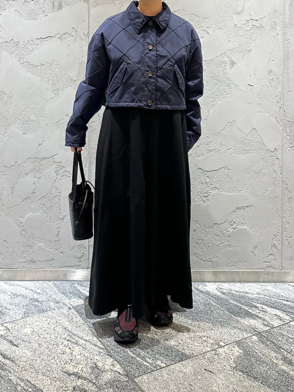 ブルー系のダウンジャケット/コート、ブラック系のワンピース、ブラック系のハンドバッグを着用したレディースの冬コーディネートの2枚目の写真