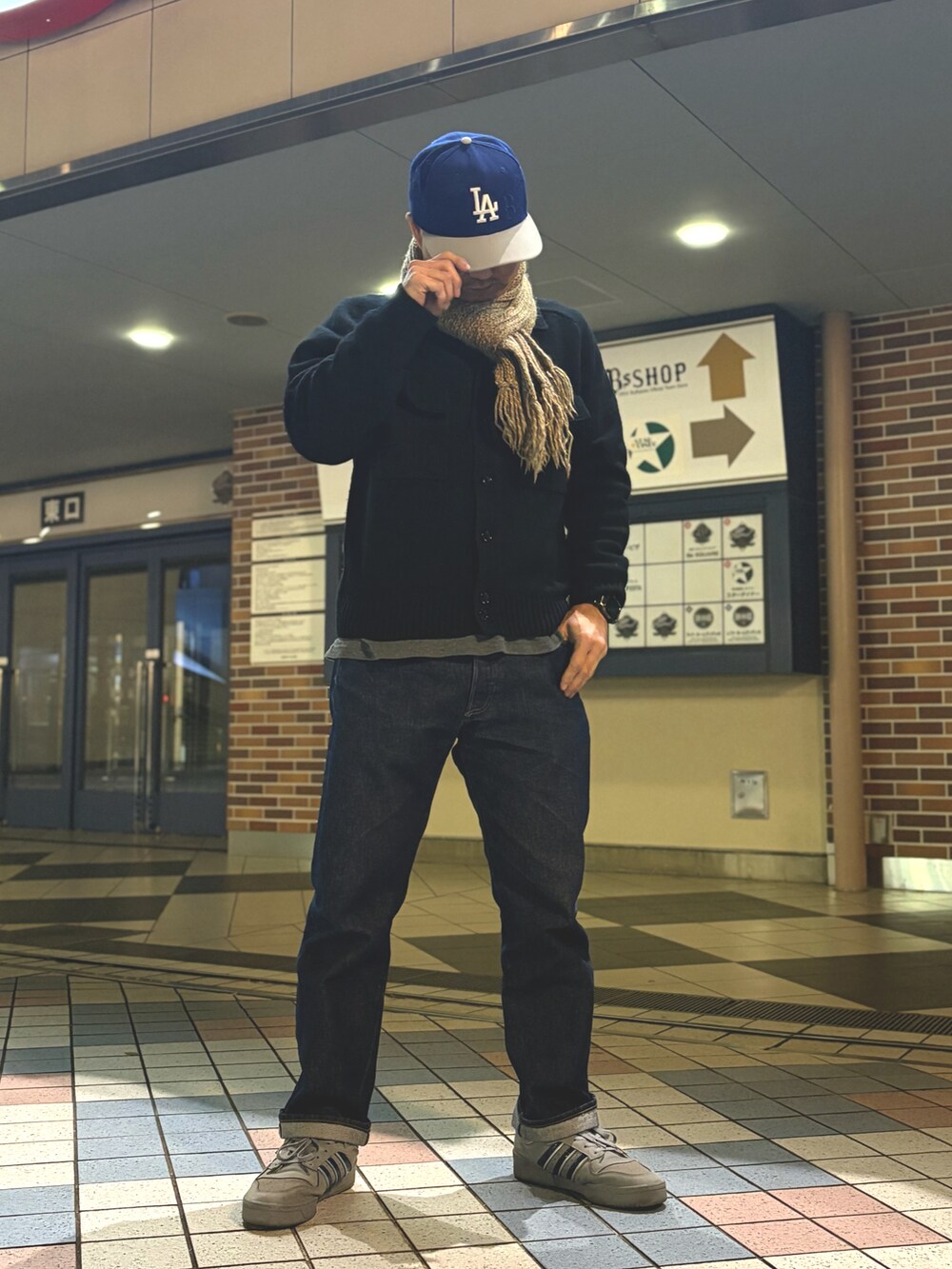 ブラック系のニット/セーター、ブルー系のデニムパンツ、グレー系のスニーカーを着用したメンズの冬コーディネートの3枚目の写真