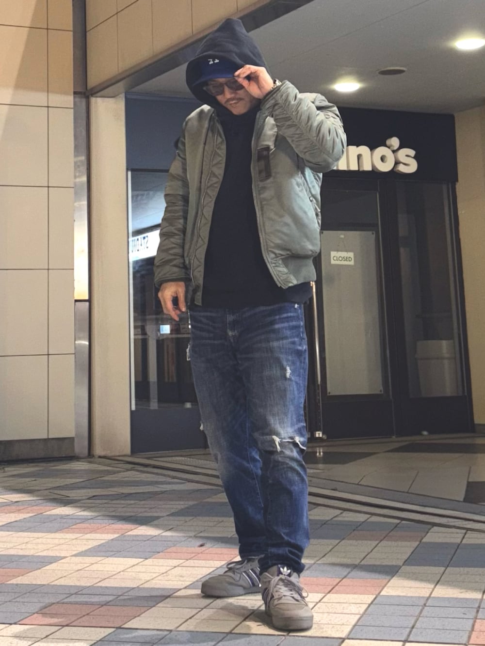 その他のMA-1、ブラック系のパーカー、ブルー系のデニムパンツを着用したメンズの冬コーディネートの3枚目の写真