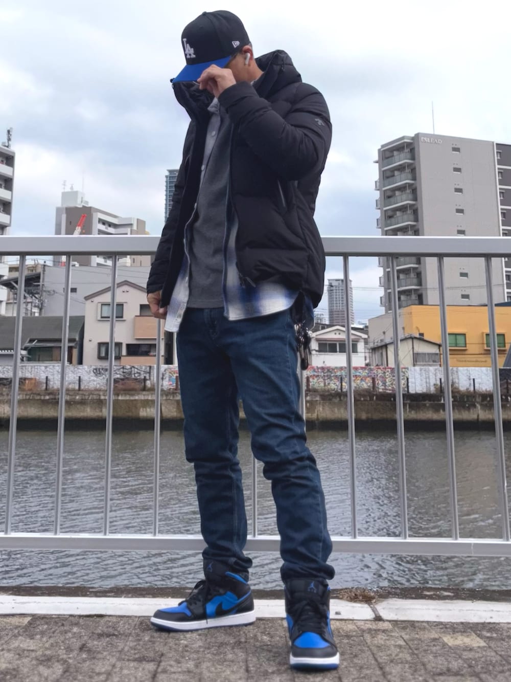 ブラック系のダウンジャケット/コート、ブルー系のシャツ/ブラウス、ブルー系のデニムパンツを着用したメンズの冬コーディネートの2枚目の写真