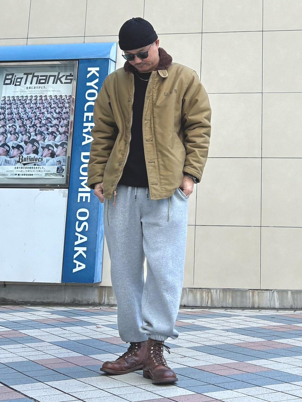 ブラウン系のブーツ、その他のミリタリージャケット、グレー系のスウェットパンツを着用したメンズの冬コーディネートの2枚目の写真