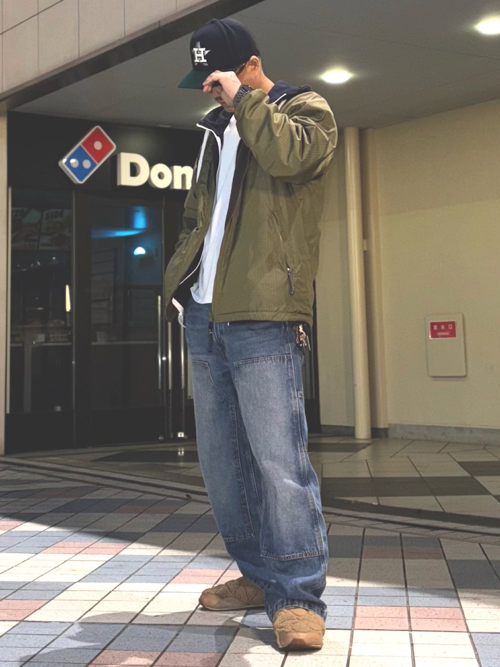 グリーン系のナイロンジャケット、ブルー系のパーカー、ホワイト系のTシャツ/カットソーを着用したメンズの春コーディネートの2枚目の写真