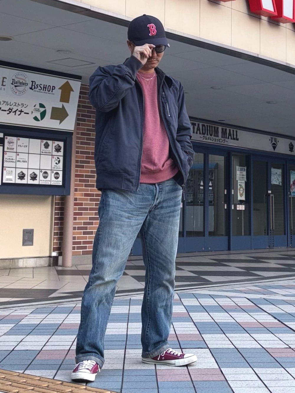 ブルー系のその他アウター、レッド系のスウェット、ブルー系のデニムパンツを着用したメンズの冬コーディネートの2枚目の写真