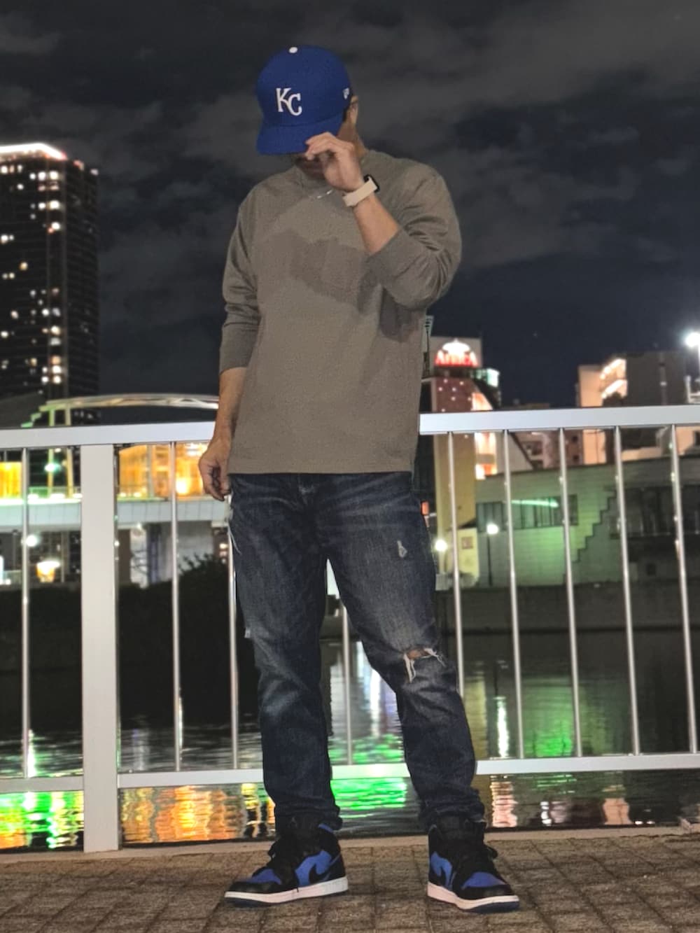 グレー系のTシャツ/カットソー、ブルー系のデニムパンツ、ブルー系のスニーカーを着用したメンズの春コーディネートの2枚目の写真