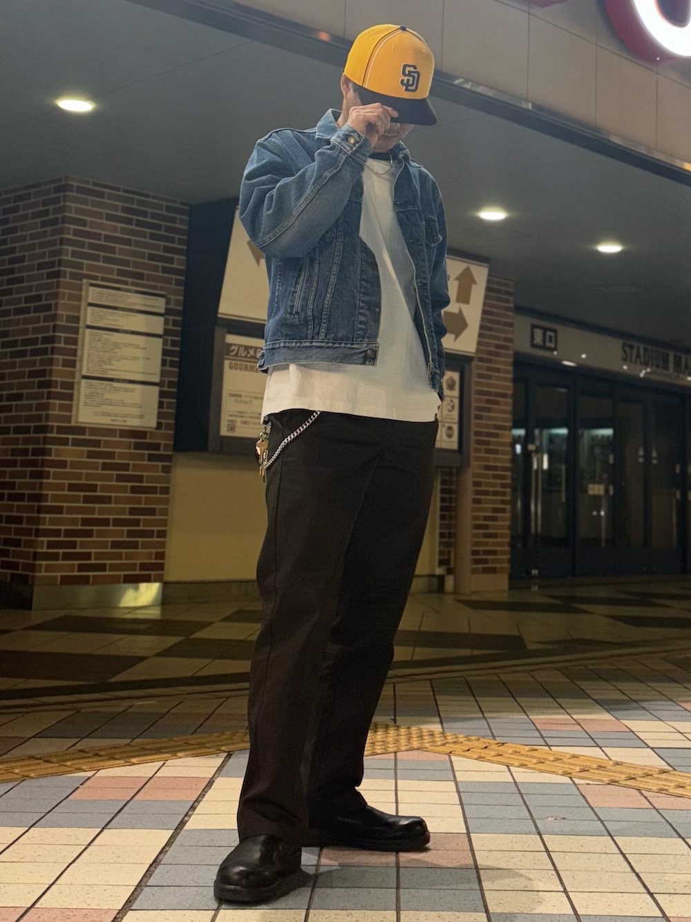 ブルー系のデニムジャケット、ホワイト系のTシャツ/カットソー、ブラウン系のチノパンツを着用したメンズの春コーディネートの2枚目の写真