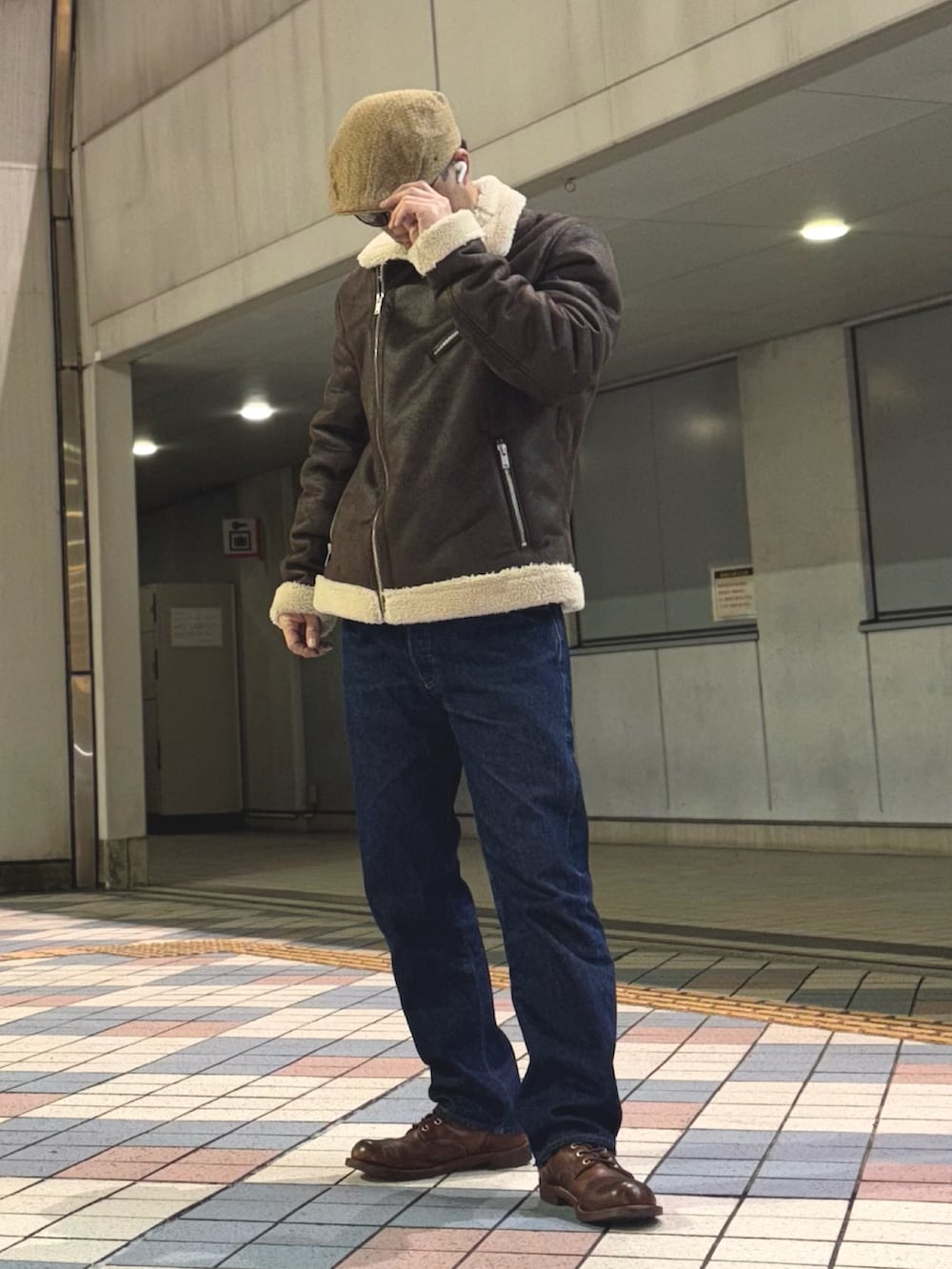 ブラウン系のライダースジャケット、ブルー系のデニムパンツ、ブラウン系のブーツを着用したメンズの冬コーディネートの2枚目の写真