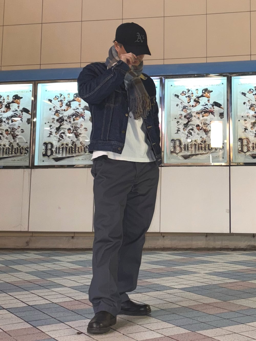 ブルー系のデニムジャケット、グレー系のチノパンツ、ブラック系のブーツを着用したメンズの冬コーディネートの2枚目の写真