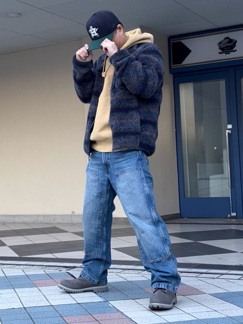 ブルー系のその他アウター、イエロー系のパーカー、ブルー系のデニムパンツを着用したメンズの冬コーディネートの3枚目の写真